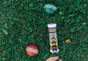 croquet mallet and balls on grass