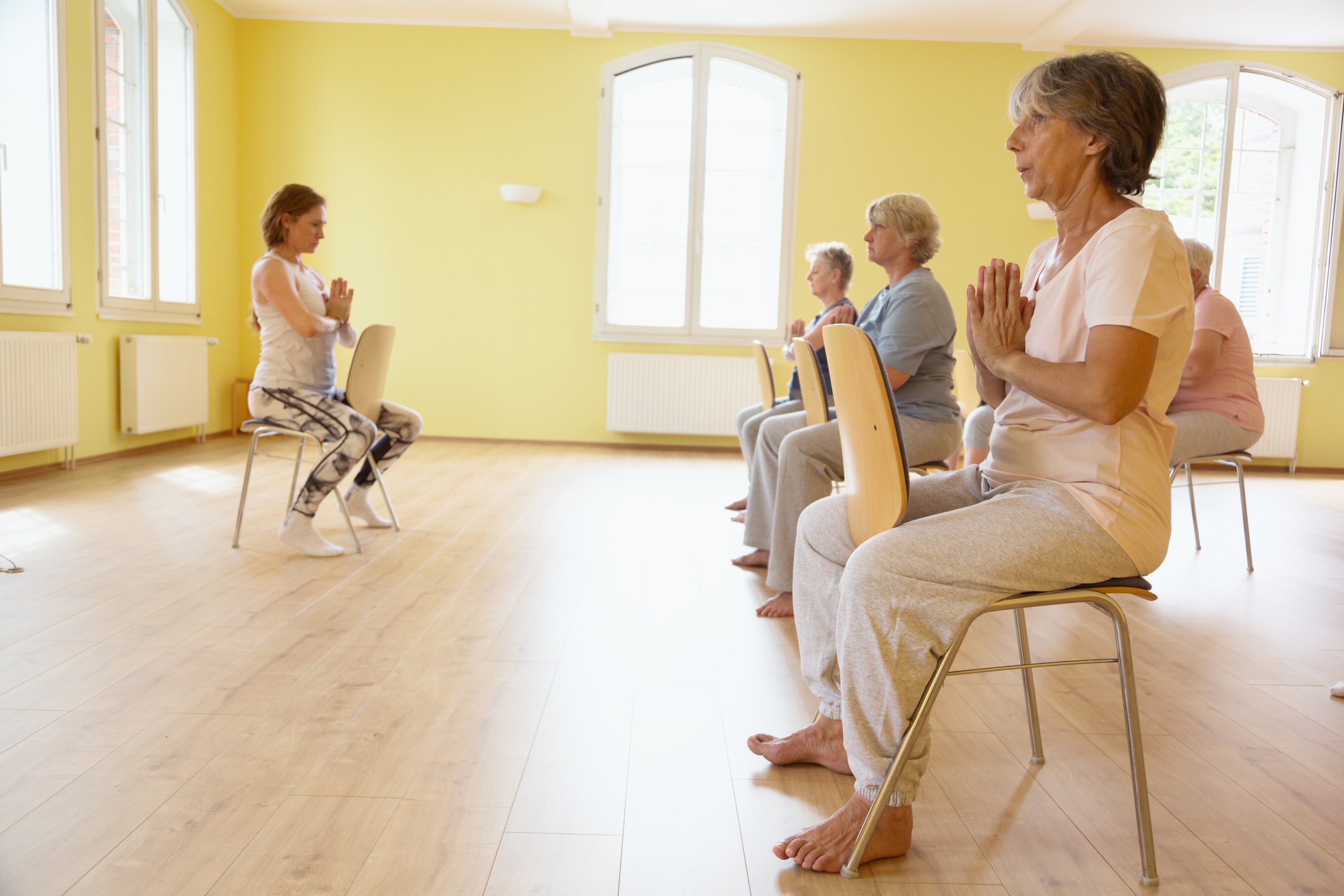 Beginner Tai Chi class for seniors with chairs available for balance