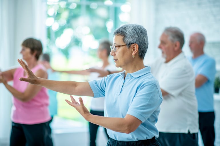 Senior practicing a beginner Tai Chi balance movement